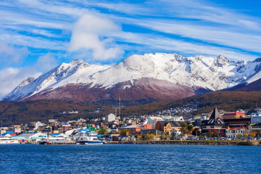 La ville d'Ushuaïa vue depuis le canal Beagle, adossée aux montagnes enneigées La ville d'Ushuaïa vue depuis le canal Beagle, adossée aux montagnes enneigées
