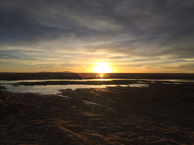 Visiteurs au bord d'un bassin d'eau chaude fumant au lever du soleil, sur l'altiplano bolivien Visiteurs au bord d'un bassin d'eau chaude fumant au lever du soleil, sur l'altiplano bolivien