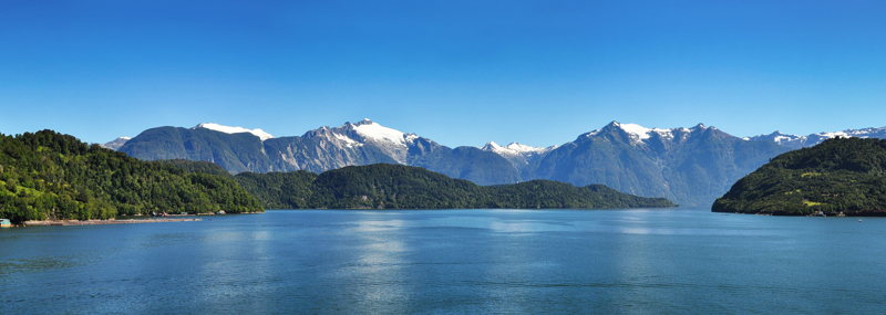 Montagnes enneigées et eaux calmes des fjords du sud du Chili, vus du ferry Montagnes enneigées et eaux calmes des fjords du sud du Chili, vus du ferry