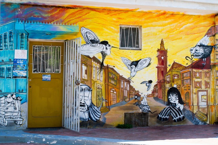 Fresque murale aux tons orangés autour d'une porte, street art de Valparaíso