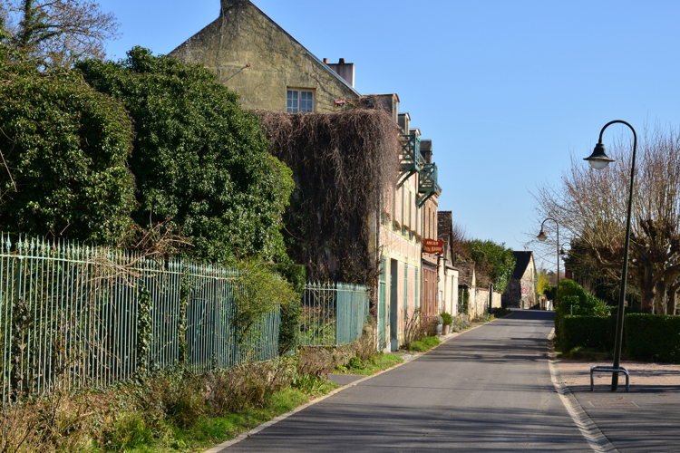 Rue du village de Giverny bordée de maisons en pierre au printemps Rue du village de Giverny bordée de maisons en pierre au printemps