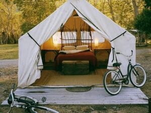  Tente de glamping meublée avec lit, terrasse en bois et vélo, dans un camping haut de gamme