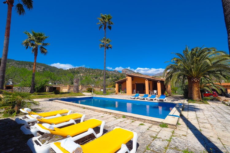 Piscine et transats d'une villa à Alaró, au pied de la Serra de Tramuntana Piscine et transats d'une villa à Alaró, au pied de la Serra de Tramuntana