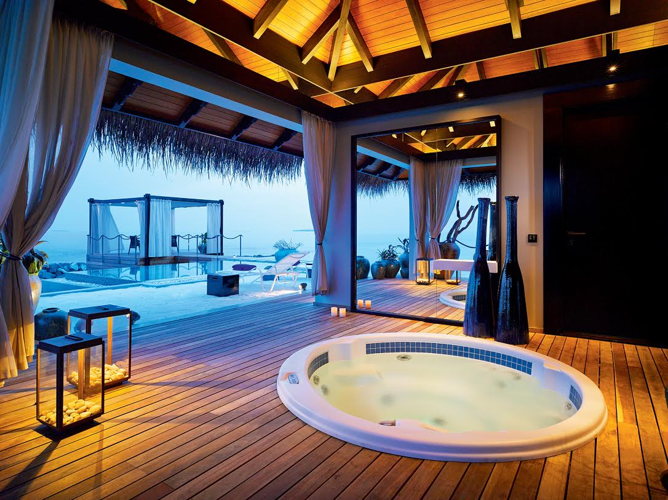 Jacuzzi sur une terrasse en bois face à l'océan au spa du Velaa Private Island