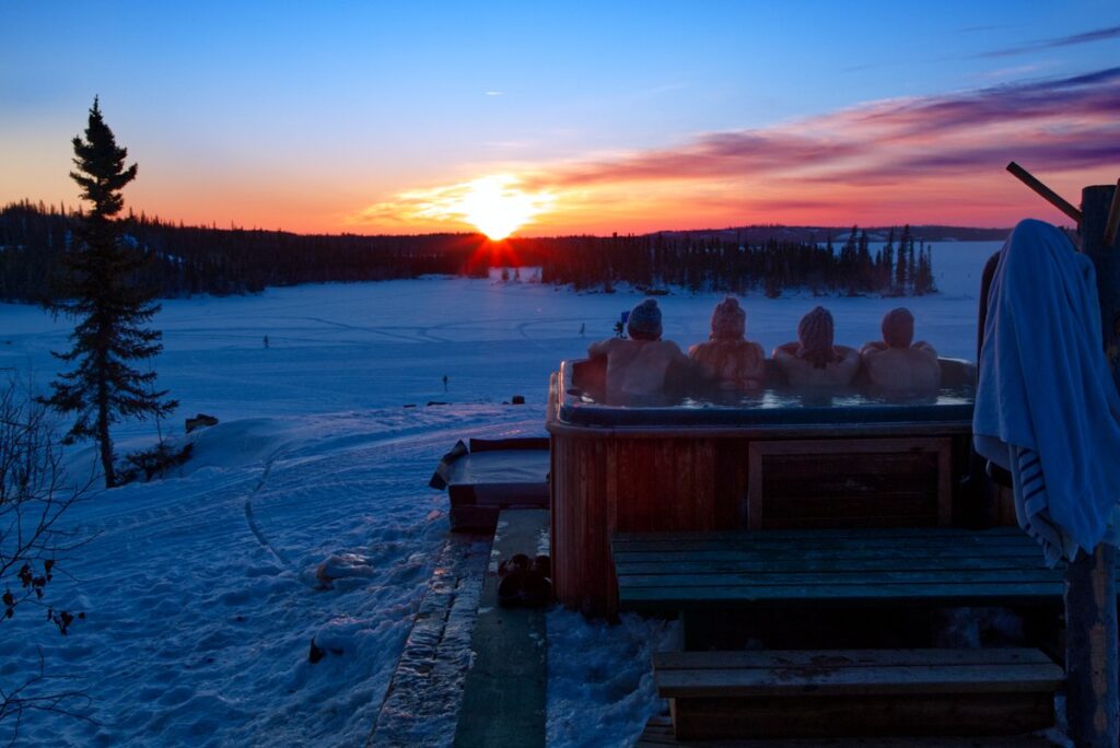 Séance Jacuzzi en contemplant le coucher de soleil sur l'horizon blanc de neige Séance Jacuzzi en contemplant le coucher de soleil sur l'horizon blanc de neige