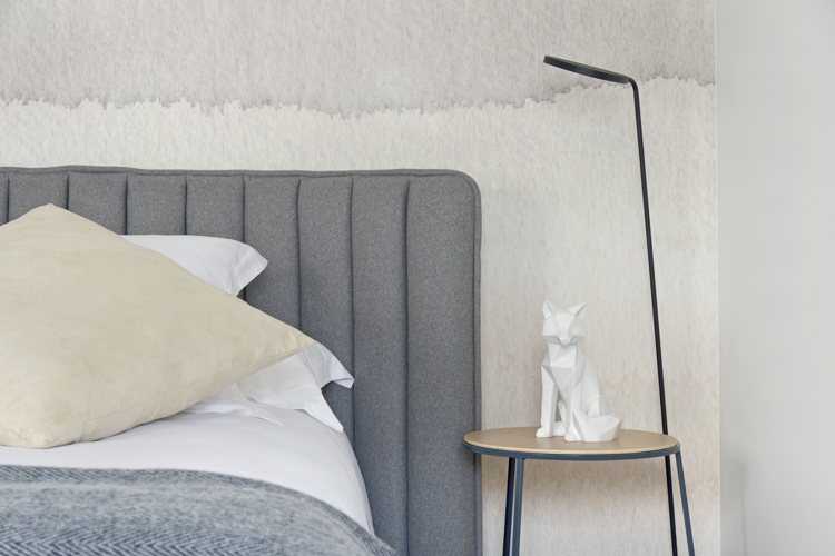 La tête du lit avec sa lampe de chevet