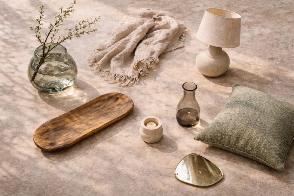 Vase, plateau en bois, coussin en lin et lampe en céramique mate