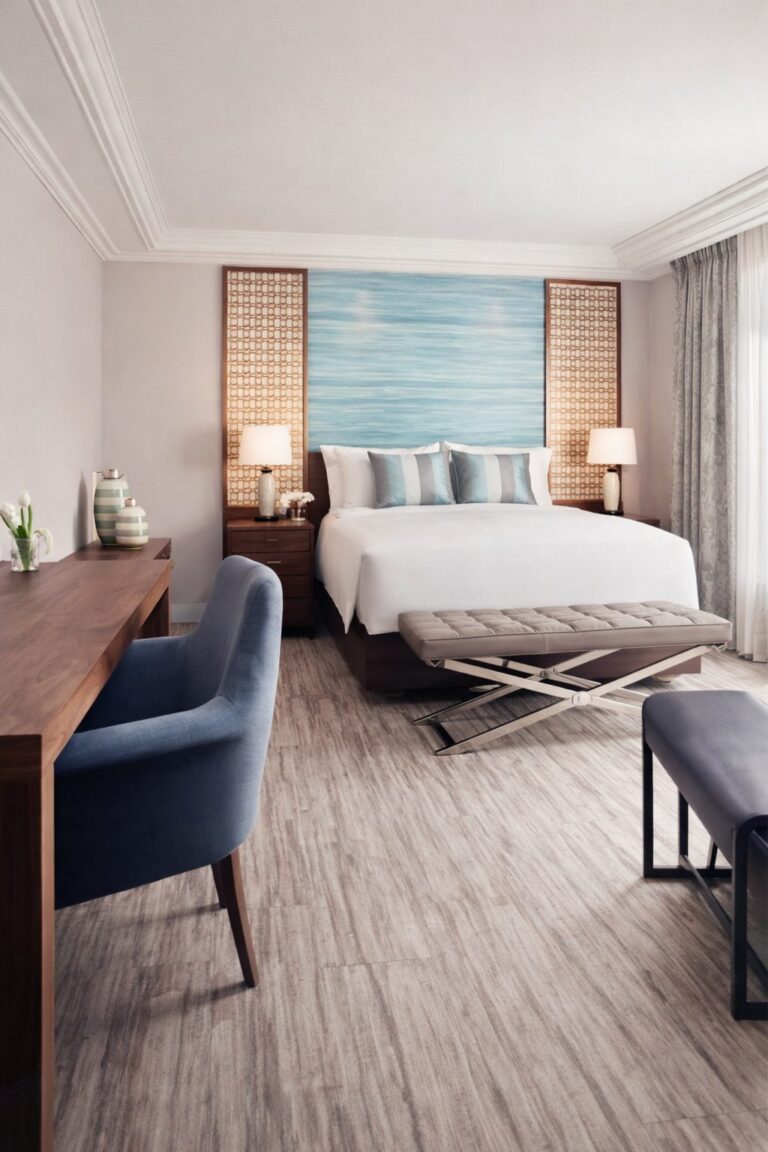 Chambre du Ritz-Carlton Santiago, lit king size et fauteuil bleu face à la baie vitrée