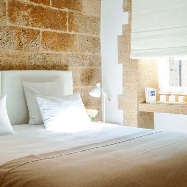 Chambre blanche aux murs de pierre d'une des adresses françaises du numéro
