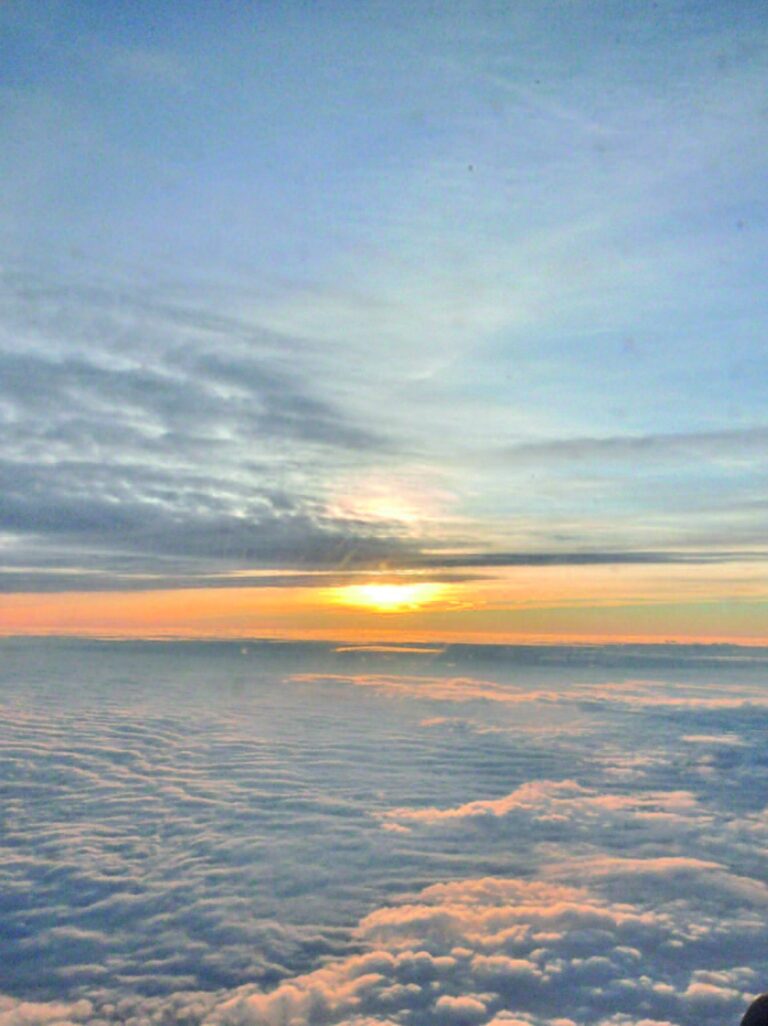 Le soleil au-dessus de la couche de nuages, vu d'un hublot