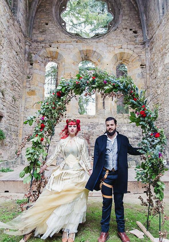 Mariés en tenue steampunk devant une abbaye